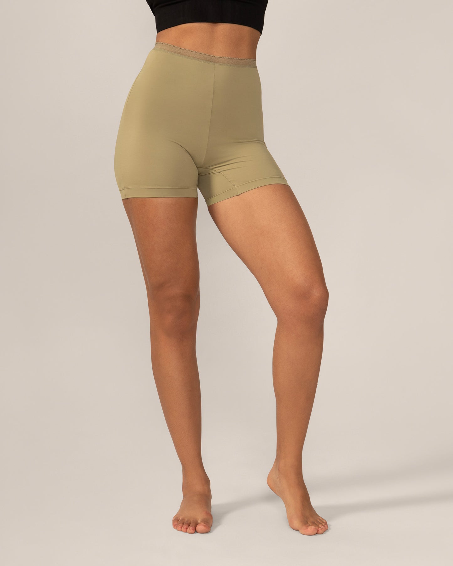 Person wearing olive green anti chaffing shorts on a plain background