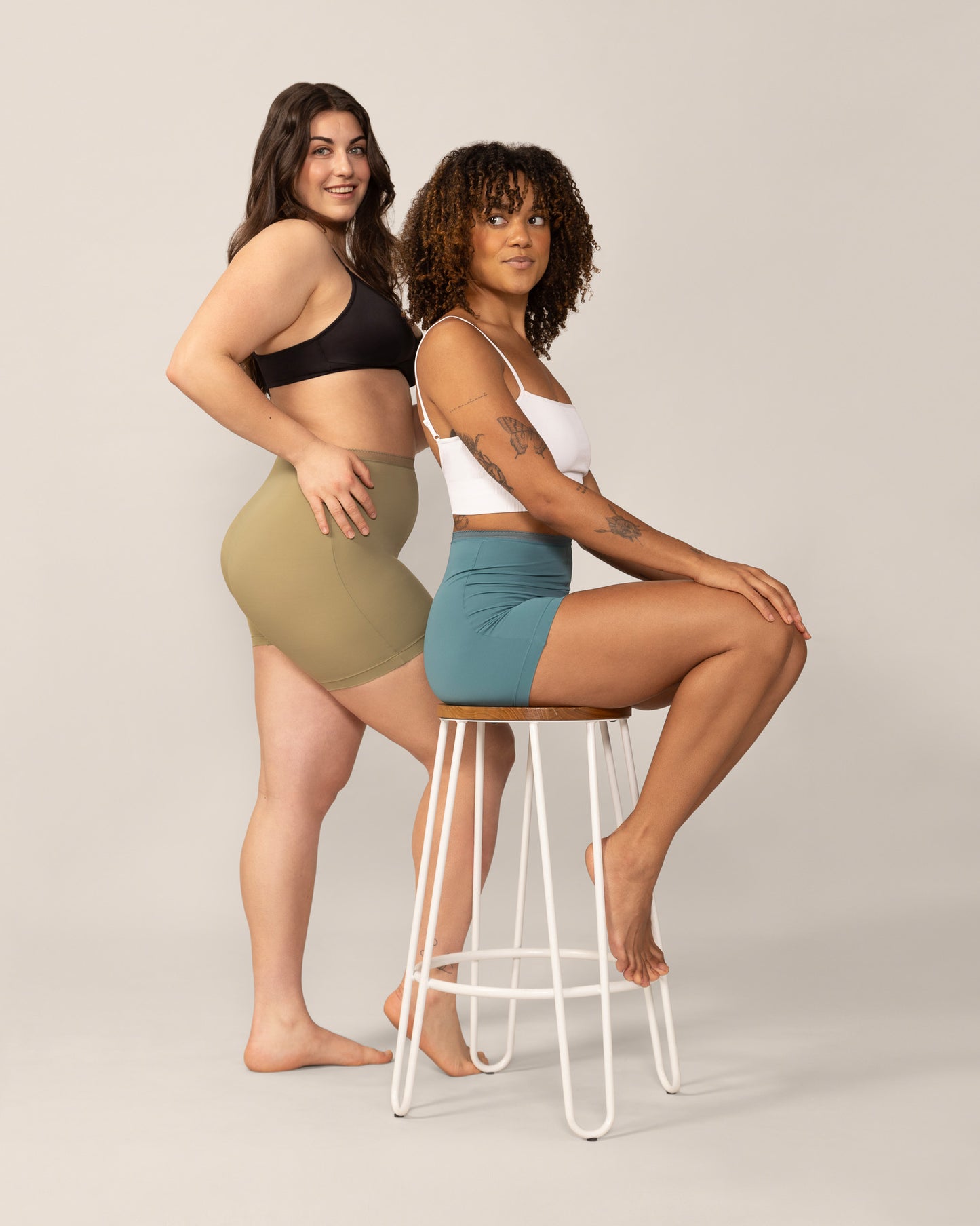 Two women wearing anti chaffing undershorts on a plain background
