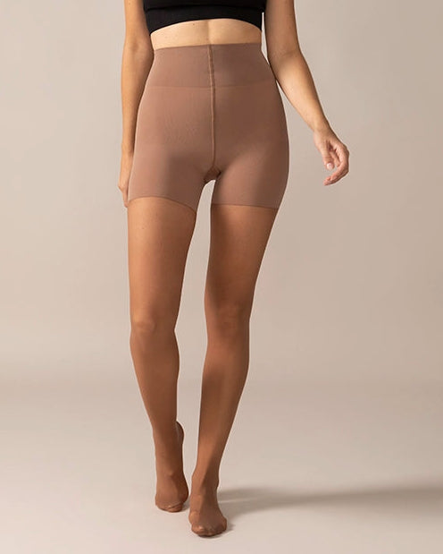 Woman wearing a black top and coffee tights on a neutral background